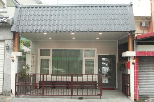 ein Haus mit einer Bank auf der Veranda in der Unterkunft Sun Light Guesthouse in Hualien