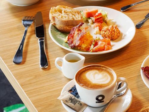 ベオグラードにあるMama Shelter Belgradeの2枚の皿に盛られた食べ物とコーヒーカップが置かれたテーブル