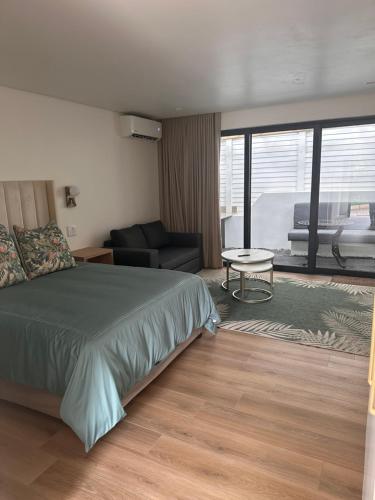 una camera da letto con un letto e un soggiorno di Two Tides a Ballito