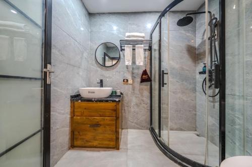 een badkamer met een wastafel en een douche bij Phoenix Geometry Light Accommodation in Fenghuang