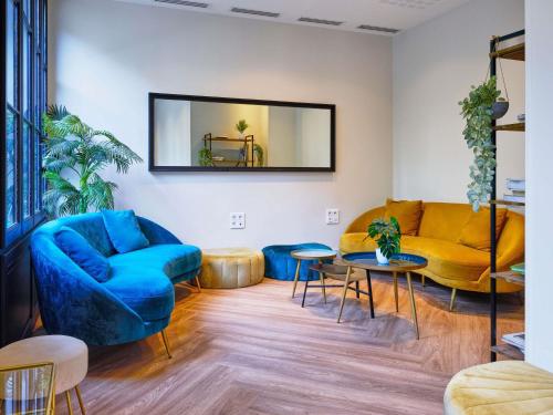 a living room with a couch and a table at Adagio Serris Val d'Europe in Serris