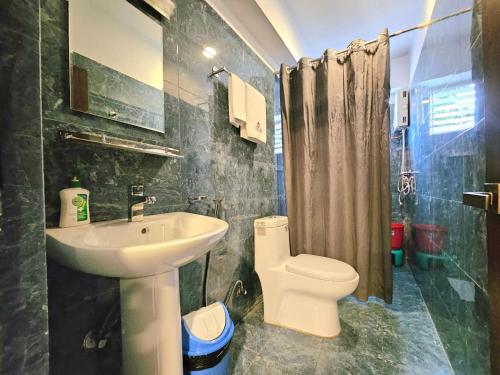 a bathroom with a sink and a toilet at Sagarmatha Apartment Hotel in Pātan