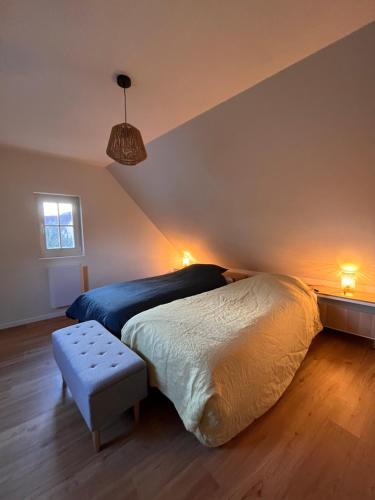 a bedroom with a bed and a bench in it at La cour du vigneron in Turckheim