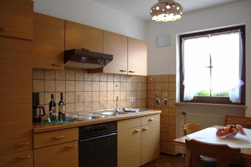 a kitchen with wooden cabinets and a table and a window at Gasthof Hotel Schwarzes Roß in Bad Berneck im Fichtelgebirge