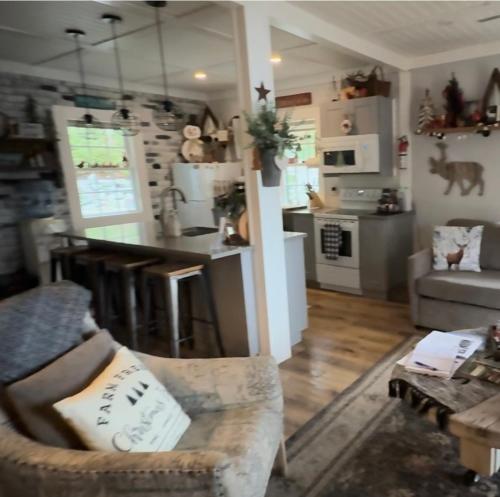 ein Wohnzimmer mit Couch und Küche in der Unterkunft Mile 77 Cottages Lakefront 100yr old Railway Cottage in Youbou