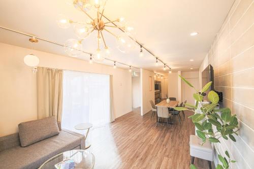 a living room with a couch and a chandelier at KOTOVilla JR琴平駅近く丸々貸切一棟室内アスレチック in Kotohira