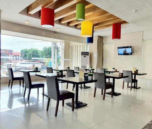 une salle à manger avec des tables, des chaises et des lumières colorées dans l'établissement District 21 Hotel, à Iloilo