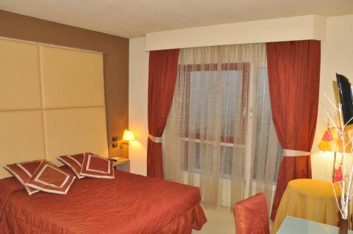 a hotel room with a red bed and a window at Relais Villa Annamaria Bed end Breakfast in Istrana