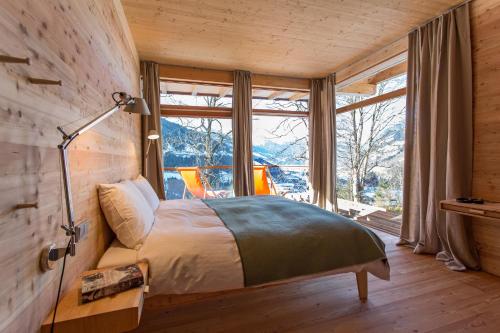 a bedroom with a bed and a large window at Alpenlofts in Bad Gastein
