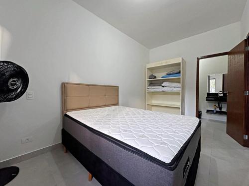 un dormitorio con una cama en una habitación en Casa aconchegante piscina, en Matinhos