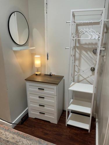 a white dresser with a lamp and a mirror at Nest Aparthotel Broadway in New York