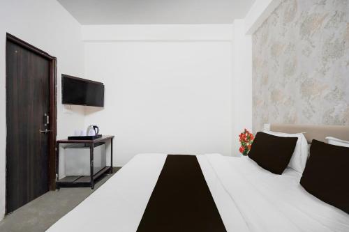 - une chambre avec un grand lit blanc et une télévision dans l'établissement Hotel O City Park Kota Formerly Oxyluxe, à Kota