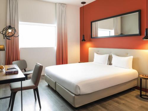 une chambre d'hôtel avec un lit et un bureau dans l'établissement Adagio Paris 19ème Cité de la Musique, à Paris