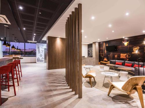 Un vestíbulo con mesas y sillas y un bar. en ibis Barranquilla, en Barranquilla