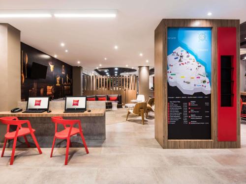 a hotel lobby with red chairs and a sign at ibis Barranquilla in Barranquilla