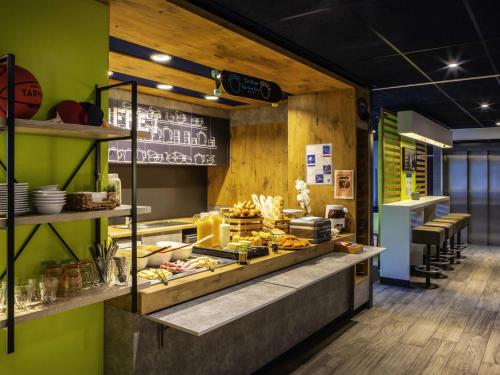 クリシーにあるイビス バジェット パリ クリシー マリーの緑の壁のレストラン、食べ物を取り揃えたカウンター