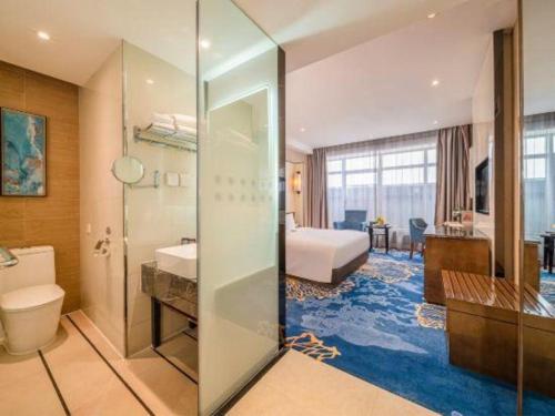 une chambre d'hôtel avec un lit et une salle de bain dans l'établissement Nanning Champs Elysees Hotel, à Nanning