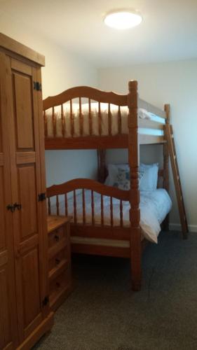 1 Schlafzimmer mit 2 Etagenbetten und einem Schrank in der Unterkunft 17 The Green Holiday Apartment in Tenby