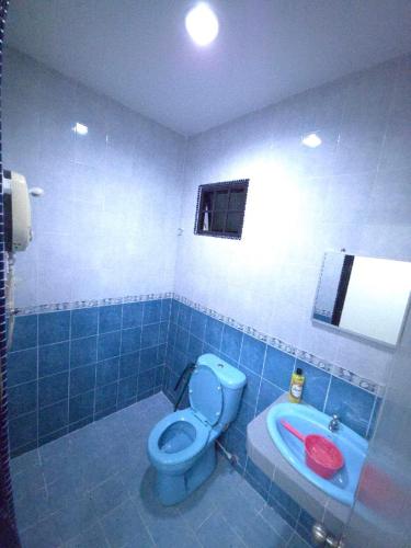 a bathroom with a blue toilet and a sink at Hotel Bumimas in Kuantan