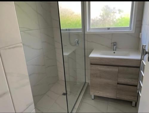 a bathroom with a shower and a sink at Northcote holiday home- Next stop CBD in Auckland