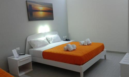 a bedroom with a bed with two stuffed animals on it at Residence Le Isole in Marsala