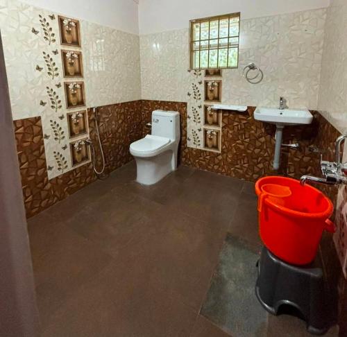 a bathroom with a toilet and a sink at Kadugadde Homestay in Sakleshpur