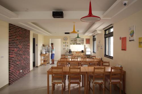 une salle à manger avec des tables et des chaises en bois ainsi qu'une cuisine dans l'établissement Happy Together B&B, à Wujie