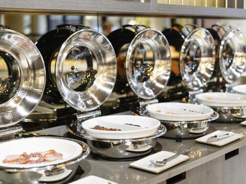 a row of plates and pans on a buffet at Novotel Leicester in Leicester