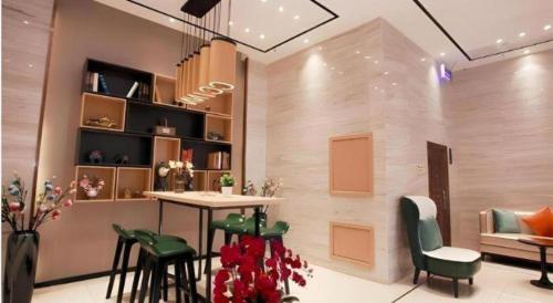 ein Zimmer mit einem Tisch und einigen Stühlen sowie einem Tisch und einem Regal in der Unterkunft City Comfort Inn Shenyang Railway Station Taiyuan Street Wanda Plaza in Shenyang