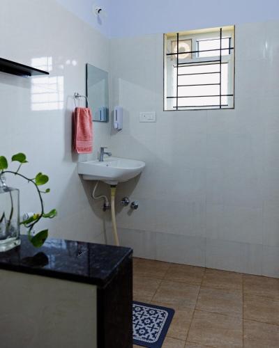 a bathroom with a sink and a glass shower at Starlight Manor Mavallipura in Bangalore