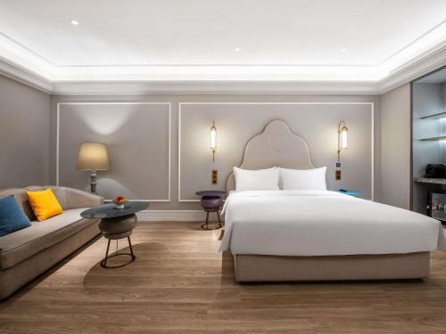 平阴山东平阴美居酒店的带一张大床和一张沙发的卧室