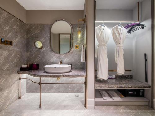 平阴山东平阴美居酒店的浴室里有洗手池和镜子