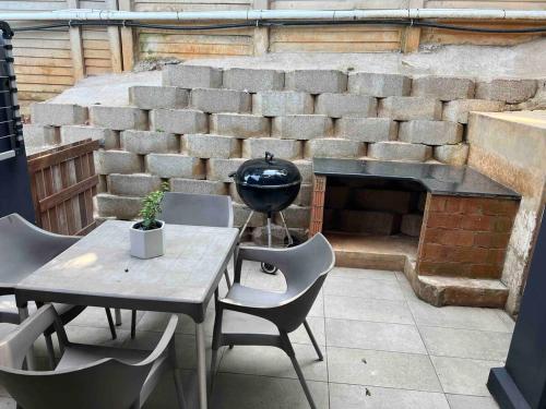 a patio with a table and chairs and a brick fireplace at Three Waves in Ballito