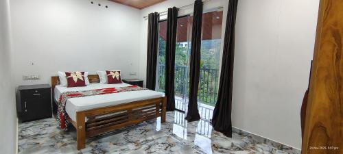 GREEN LEAF PREMIUM VILLA munnar في مونار: غرفة نوم بها سرير ونافذة كبيرة
