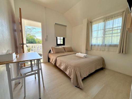 a bedroom with a bed and a desk and a window at D sleep Home Chiangmai in Chiang Mai
