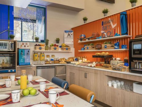 Una cocina grande con una mesa con comida encima. en ibis budget Valencia Centro Puerto, en Valencia