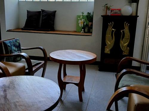 Cette chambre dispose de deux tables, de chaises et d'une cheminée. dans l'établissement 119 Boutique Natural Wellness Chiang Mai, à Chiang Mai