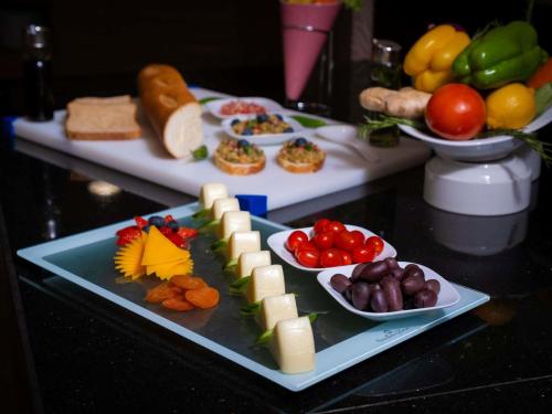 ein Tisch mit zwei Tabletts mit Käse und anderen Speisen in der Unterkunft Mercure Makkah Aziziah in Mekka