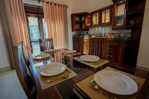 a kitchen with a table with plates and utensils at Golden Gate in Galle
