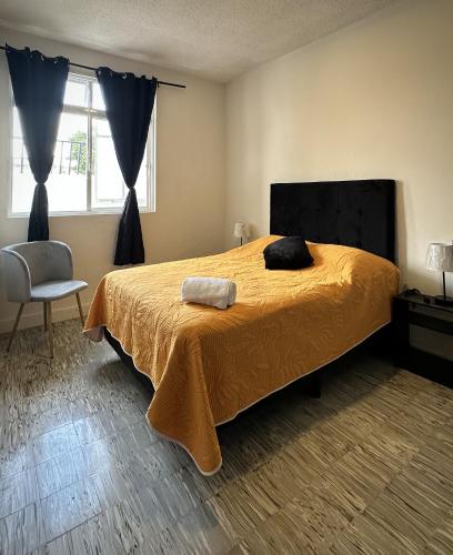 a bedroom with a bed and a chair and a window at DCalli Next to the Alameda, terrace and confort in Orizaba