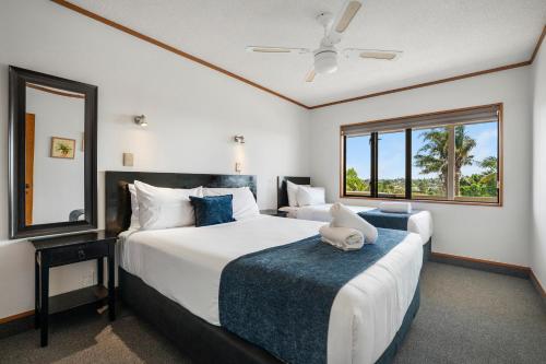 a bedroom with two beds and a large window at Summit Motor Lodge in Tauranga