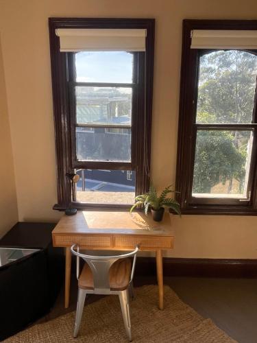 a desk with a chair in front of a window at Glengarry Castle Hotel in Sydney