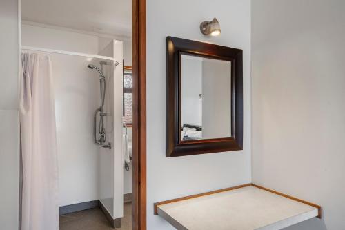 a mirror on a wall next to a bathroom at Summit Motor Lodge in Tauranga