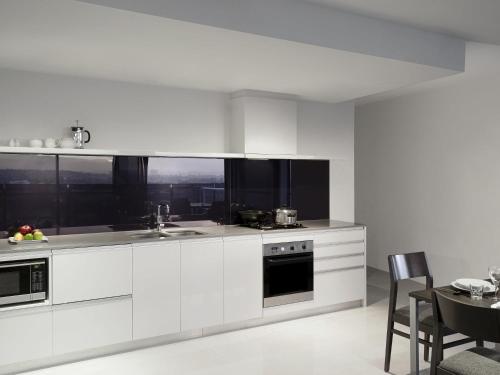 a white kitchen with a sink and a stove at Mantra Circle On Cavill in Gold Coast