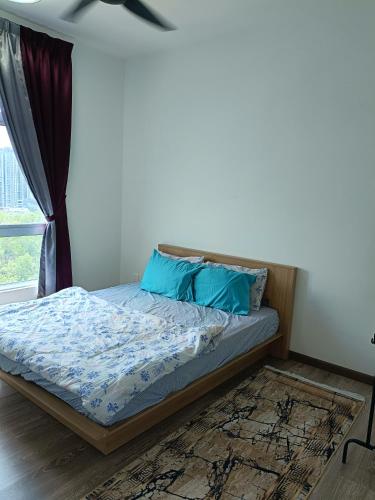 a bed with blue pillows in a bedroom at Alstenor Homestay 2 in Kajang