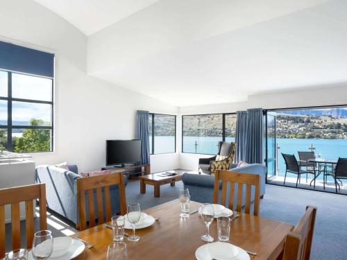 a living room with a dining table and a living room at Mantra The Point in Queenstown