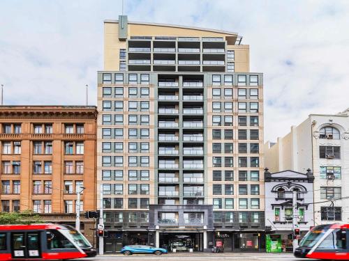 a tall building with many windows on a city street at Mantra Sydney Central in Sydney