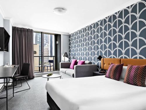 a hotel room with a bed and a couch at Mantra Sydney Central in Sydney