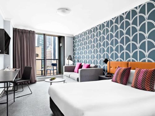 una habitación de hotel con una cama y un sofá en Mantra Sydney Central, en Sídney