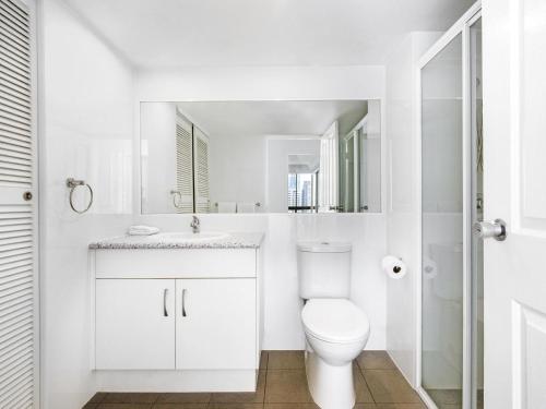 ein weißes Badezimmer mit Toilette und Waschbecken in der Unterkunft BreakFree Longbeach Resort in Gold Coast